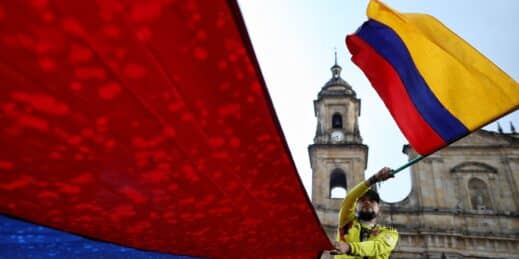 A person waving a flag at a rally in Colombia.
